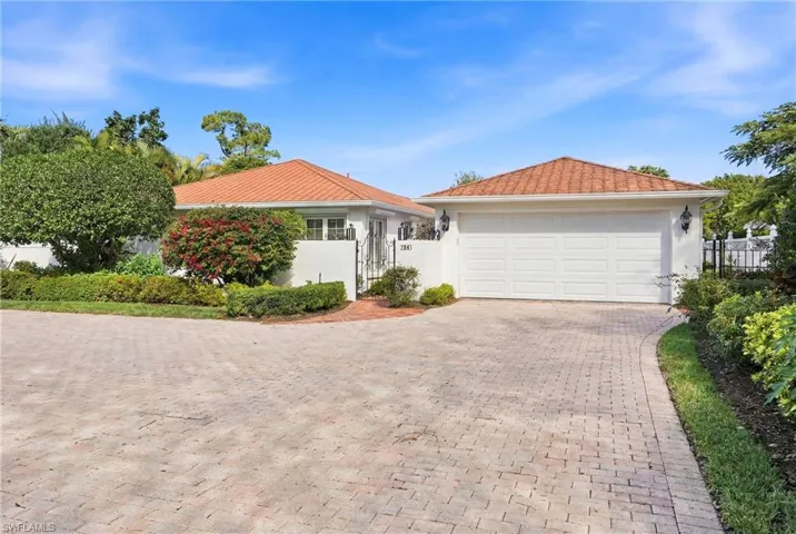 Ranch-style house featuring stucco siding, a garage, a gate, and decorative driveway
