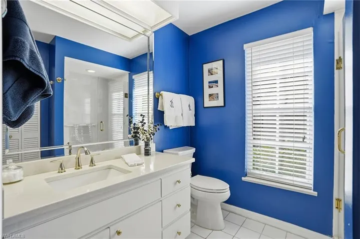 Bathroom featuring vanity, light tile patterned floors, and a stall shower