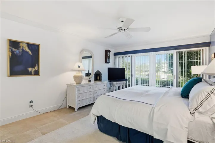 Tiled spacious second another primary bedroom featuring an ensuite bathroom, 2 closets and access to the back yard and lake views