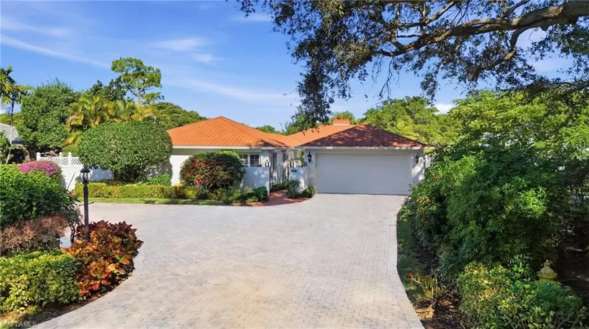 Ranch-style house featuring an attached garage, paver driveway, with guest parking and fenced yard