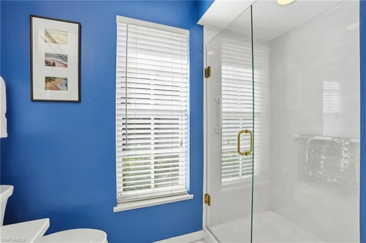 Bathroom with a shower stall and healthy amount of natural light