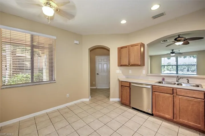 View of kitchen dining area with lighted ceiling fan to front foyer entry!