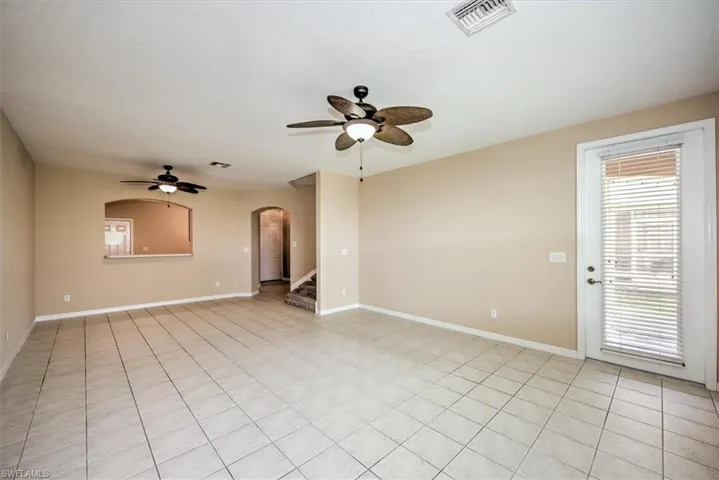 View from living room to dining room overlooking kitchen and front entryway shows door to screened lanai!