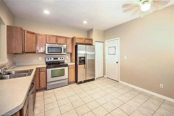 Fully applianced eat-in kitchen with recessed lighting and ceiling fan in dining area and steel insulated door leading to 2-car garage!