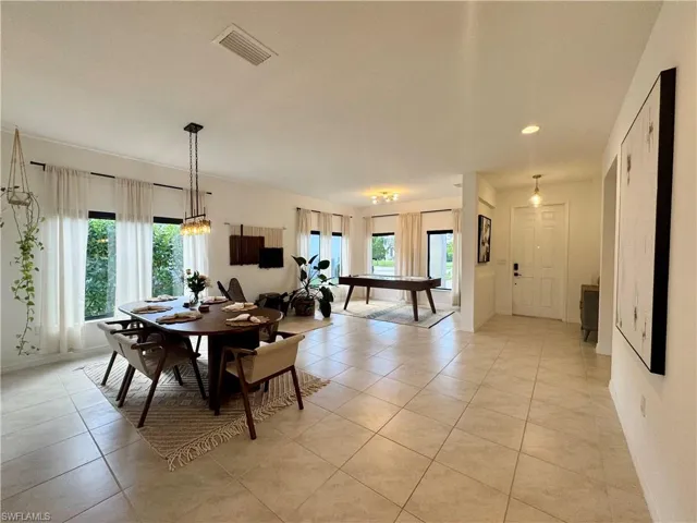 Dining area with light tile patterned flooring, baseboards, and visible vents