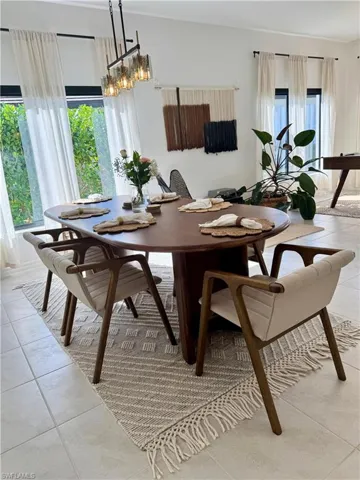 Dining space with light tile patterned floors and a notable chandelier