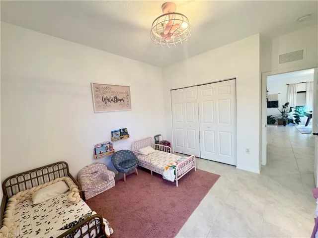 Bedroom with baseboards, a closet, and visible vents