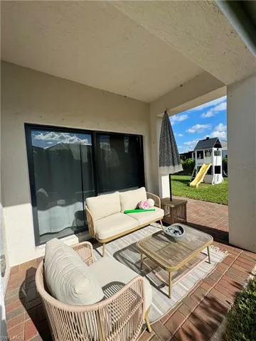 View of patio featuring an outdoor hangout area and a playground
