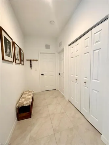Hallway with baseboards and visible vents