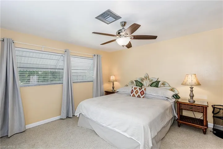 Bedroom with dark speckled floor and ceiling fan