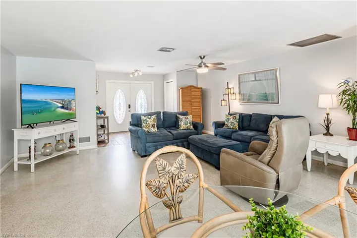 Living area featuring speckled floor and a ceiling fan