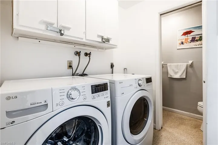 Washroom with washer and clothes dryer and cabinet space