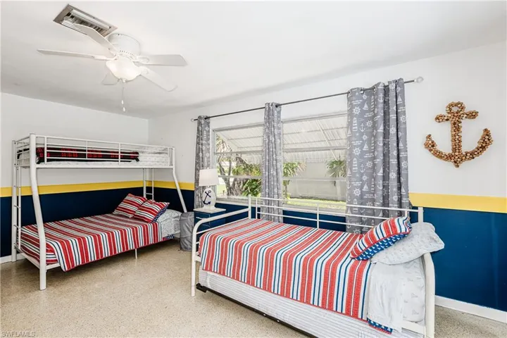 Bedroom featuring speckle patterned floor and a ceiling fan
