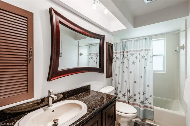 Bathroom with vanity and shower / bath combo with shower curtain