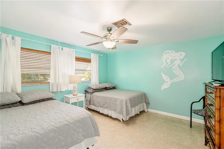 Bedroom featuring speckled floor and a ceiling fan