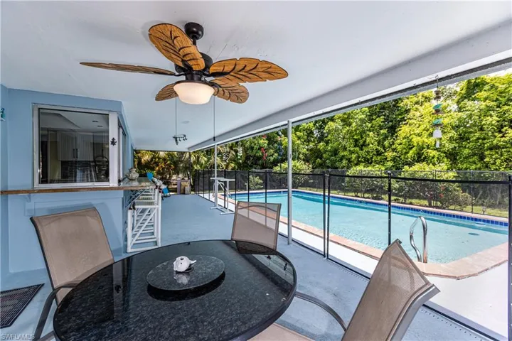 View of swimming pool featuring a ceiling fan and stairway
