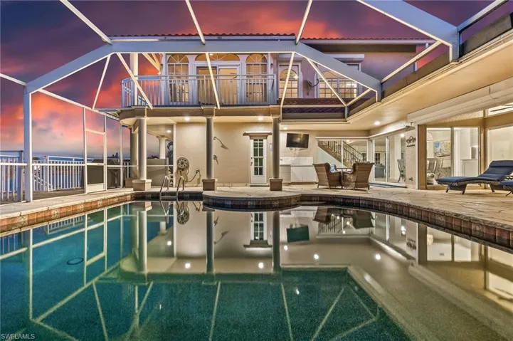 Outdoor pool featuring glass enclosure, a patio area, and a balcony
