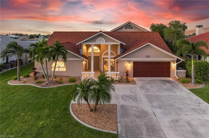 View of front of house featuring concrete driveway, an attached garage, a tile roof, and stucco siding