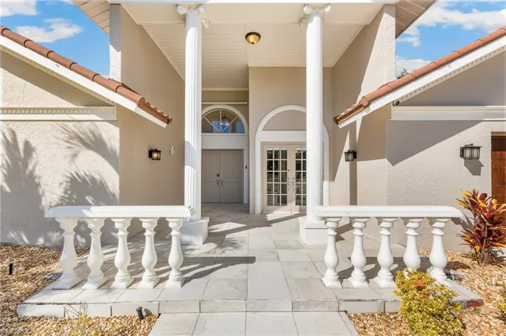 Entrance to property with a tiled roof, stucco siding, and french doors