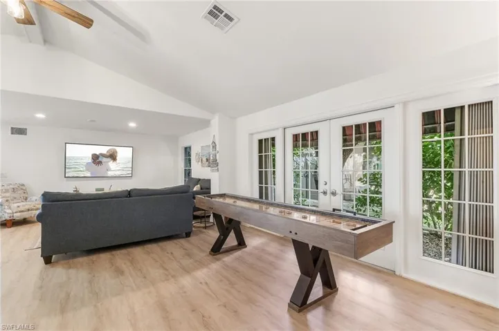Playroom featuring light wood-style floors, french doors, beamed ceiling, high vaulted ceiling, and ceiling fan