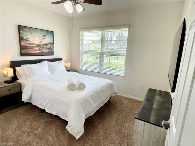 Bedroom featuring carpet floors, baseboards, and ceiling fan