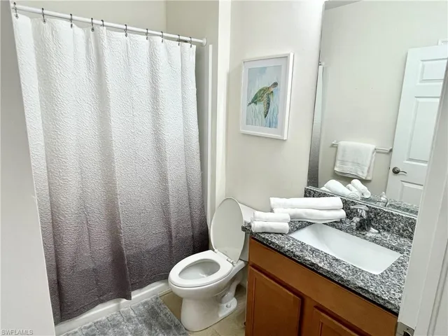 Full bathroom featuring vanity, toilet, and tile patterned flooring