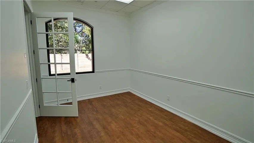 Spare room with dark wood finished floors and ornamental molding