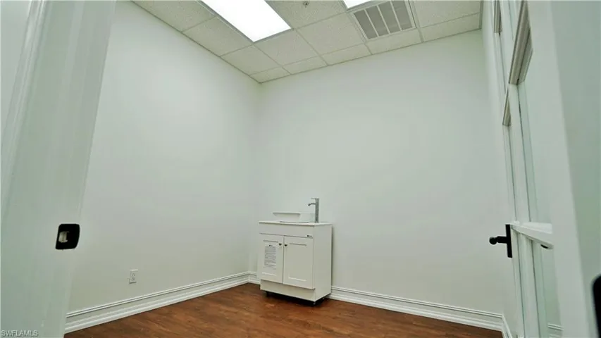Laundry area featuring a paneled ceiling and dark wood-style flooring