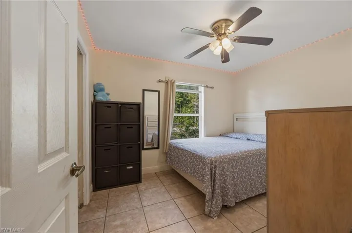 Bedroom with light tile patterned floors and ceiling fan