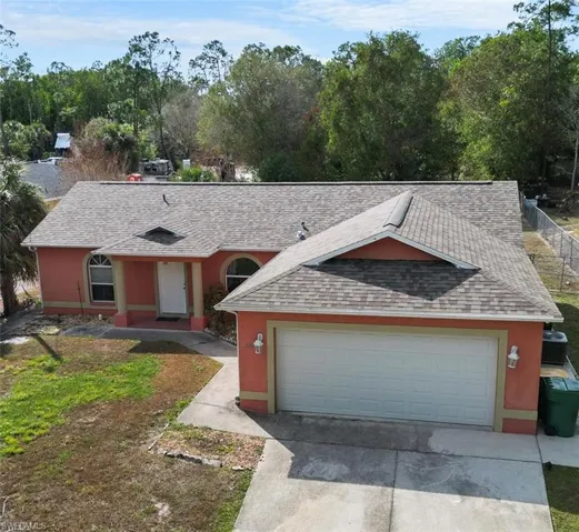 Single story home featuring roof with shingles, driveway, and stucco siding