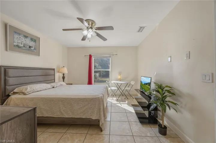 Bedroom featuring light tile patterned floors and a ceiling fan