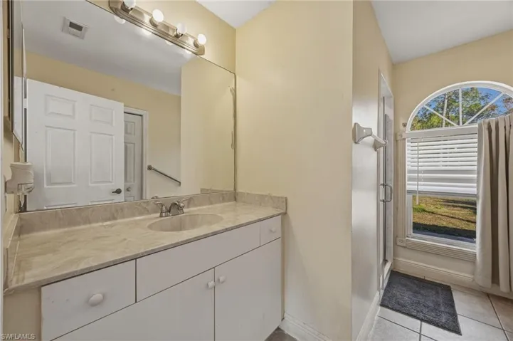 Bathroom with vanity, a stall shower, and light tile patterned flooring