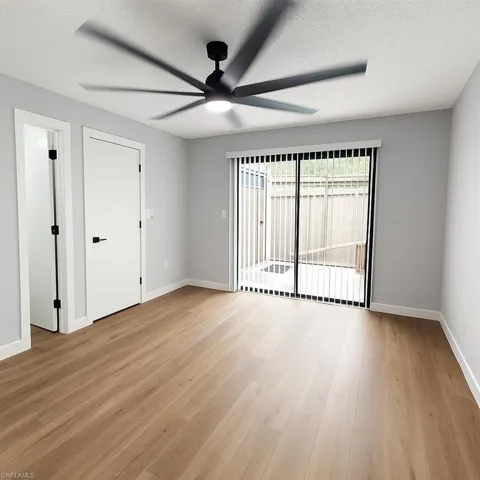 Unfurnished room featuring a ceiling fan, light wood-style floors, baseboards, and a textured ceiling