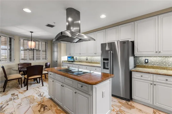 White cabinetry, granite countertops, induction oven with lovely backsplash and underlighting! Breakfast nook.