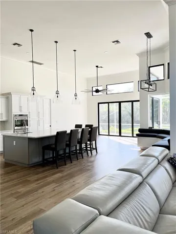 Open Living room with ornamental molding, dark wood-type flooring, and sink
