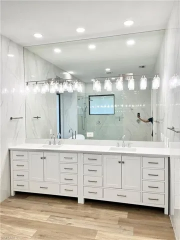 Master Bathroom featuring double vanity tiled shower, vanity, and tile walls