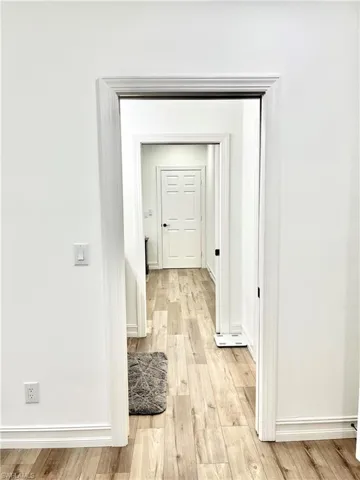Hallway featuring light hardwood connect bathroom to bedrooms