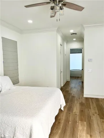Master bedroom featuring hardwood / wood-style flooring, ceiling fan, and ornamental molding