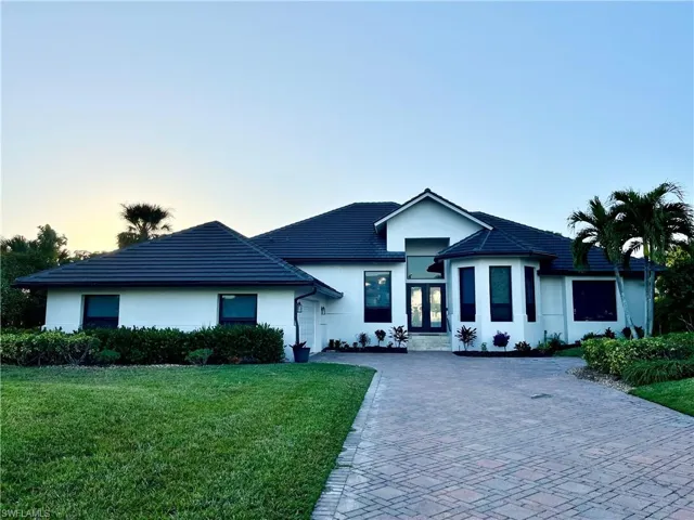 View of front house with french doors and a yard