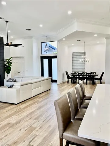Open Living room featuring ceiling fan, light hardwood / wood-style flooring, and ornamental molding