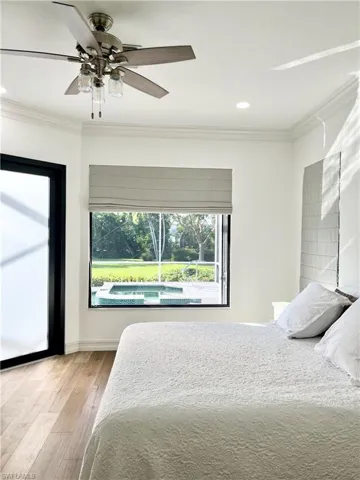 Master bedroom featuring ceiling fan, light wood-type flooring, and crown molding