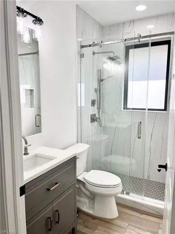 Bathroom 4 featuring vanity, toilet, and an enclosed shower