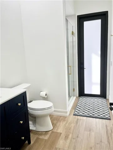 Pool bath with vanity, toilet, and a shower with door