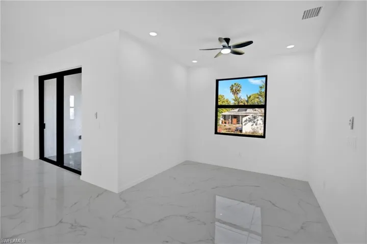 Empty room featuring light marble finish flooring, recessed lighting, and a ceiling fan