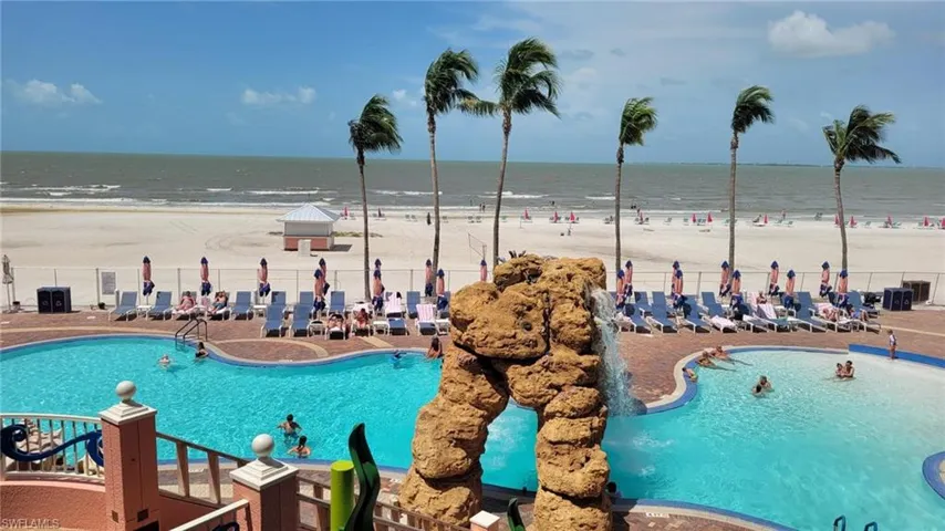 View of pool with a water view and a beach view