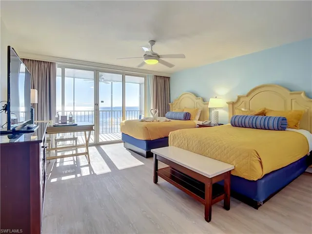 Bedroom featuring floor to ceiling windows, light hardwood / wood-style flooring, a water view, access to outside, and ceiling fan