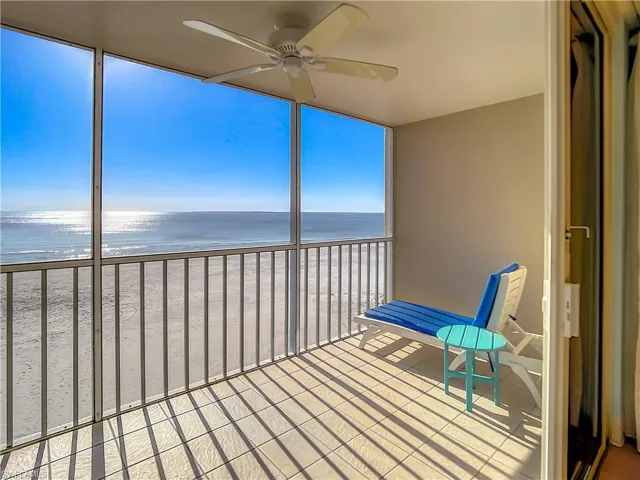 Unfurnished sunroom with a water view, a beach view, and ceiling fan