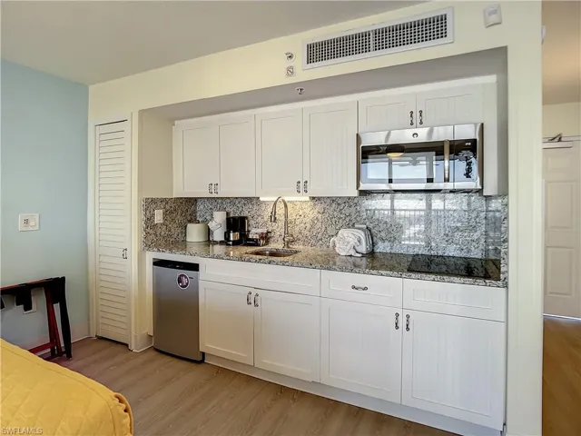 Kitchen with stainless steel appliances, tasteful backsplash, and light wood-type flooring