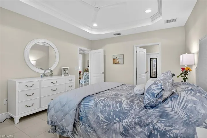 Bedroom featuring recessed lighting, tile patterned floors, ceiling fan, ornamental molding, and a raised ceiling