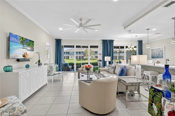 Living area featuring crown molding, light tile patterned floors, healthy amount of natural light, ceiling fan, and recessed lighting